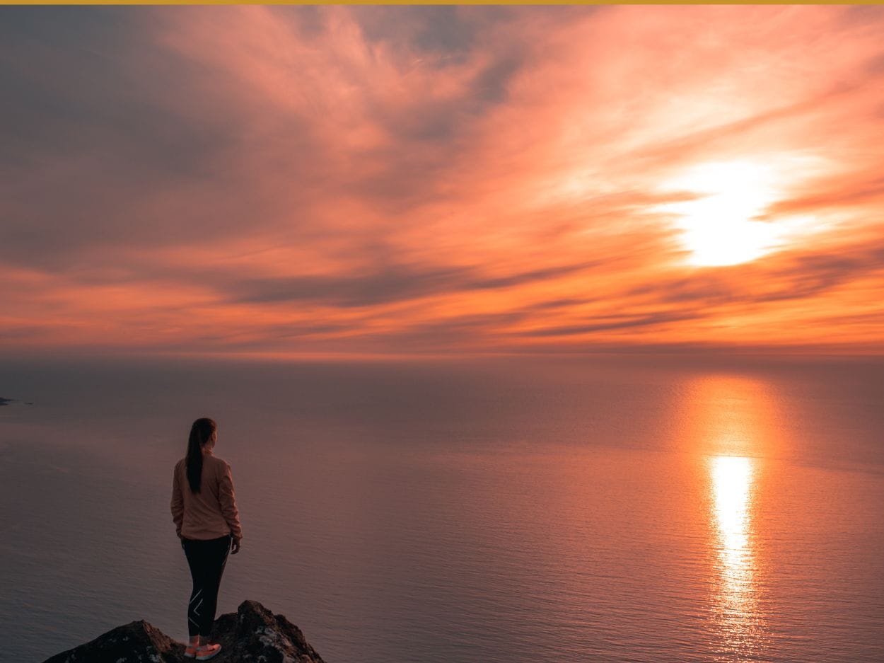 Woman Standing On Mountain Edge Looking At Sunset View more by Tobias Bjørkli from Pexels